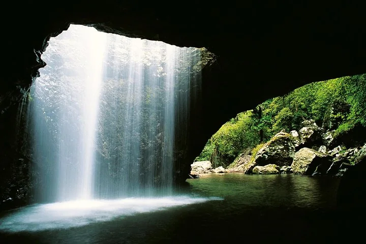 A beautiful view from inside a cave looking out at a waterfall.